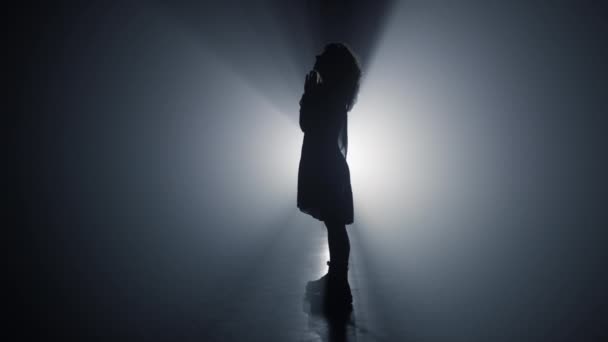 Silueta modlící se dívka uvnitř. Žena skládající ruce pro modlitbu ve tmě. — Stock video