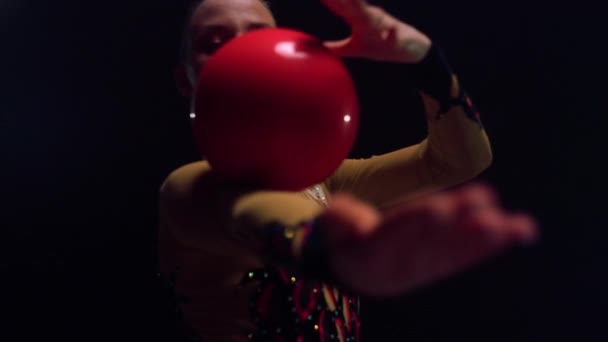 Een jonge vrouw die binnen calisthenics doet. Gymnast rollende bal bij de hand binnen. — Stockvideo