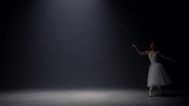 Sahneye atlayan şehvetli balerin. Bale dansçısı içeride sivri uçlu ayakkabılar giyiyor..
