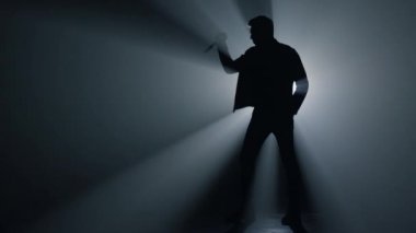 Siluet suçlusu karanlıkta bıçakla elini kaldırıyor. Tehlikeli bir suç silahı..