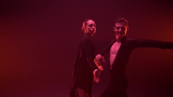 Грациозная пара, исполняющая латинский танец в помещении. Мужчина и женщина танцуют в студии. — стоковое видео