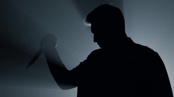 Silhouette aggressiver Verbrecher greift mit Messer an, Gefährlicher Mann mit Waffe. — Stockvideo