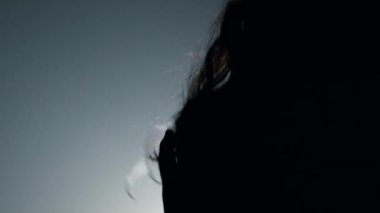 Siluet seksi manken, kafa içeride uçuşan saçlar. Güzel kız dans ediyor