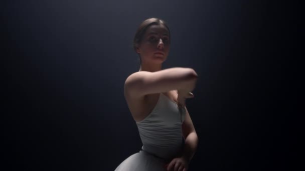 Tender ballerina uitziende camera op donkere achtergrond. Ballet danser dansles — Stockvideo
