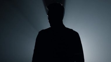 Siluet topçusu karanlıkta tabancayla el kaldırıyor. Suçlu silah taşıyor..