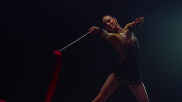 Chica gimnasta bailando con cinta dentro. Atleta haciendo gimnasia rítmica. — Vídeos de Stock