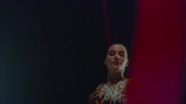 Jimnastik kurdele görünümlü kamerası olan güzel bir kadın. Kız içeride jimnastik yapıyor..