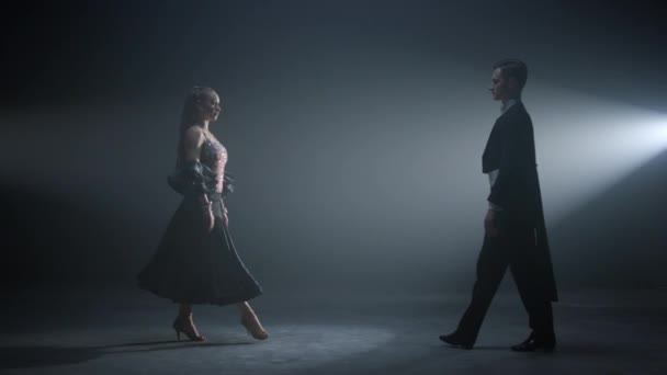 Hermosos bailarines actuando en el escenario oscuro. Pareja bailando en el salón. — Vídeos de Stock