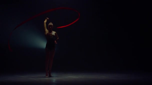 Gimnasta mostrando elementos con cinta. Mujer practicando gimnasia rítmica. — Vídeo de stock