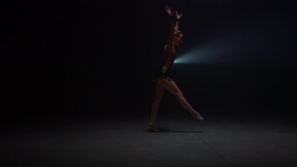 Sportliche Frau beim Handstand im dunklen Studio. Flexibles Turner-Training in Innenräumen — Stockvideo