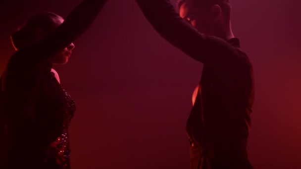 Χορευτές που εκτελούν λάτιν χορό κόκκινο φως φόντο. Χορεύοντας σε αίθουσα χορού. — Αρχείο Βίντεο