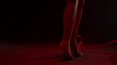 Antrenman kurdelesi takan kimliği belirsiz kadın bacakları. Tanınmayan jimnastikçi egzersizi.