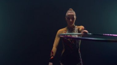 Performans hula hoop sırasında kameraya bakan zayıf kadın. Kız jimnastik yapıyor. 