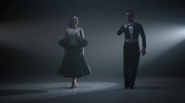 Dans eden çift gösteriden sonra eğiliyor. Sahnede dans eden dansçılar.