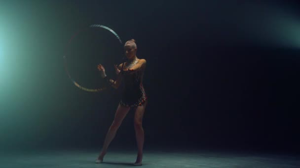 Gimnasta flexible girando hula hoop. Mujer joven practicando gimnasia rítmica — Vídeos de Stock