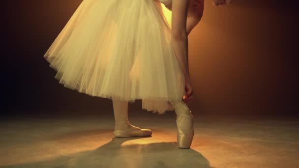 Ballerina knyter balettskor inomhus. Flexibel dansare böja över sätta på pointe — Stockvideo