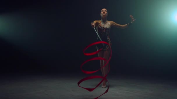 Chica flexible mostrando elementos gimnásticos con cinta. Gimnasta bailando con cinta. — Vídeos de Stock