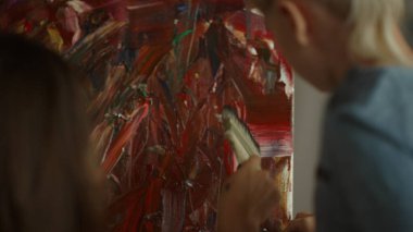 Stüdyoda kadın eli fırça darbesi. Küçük sanatçı başyapıt yaratıyor.