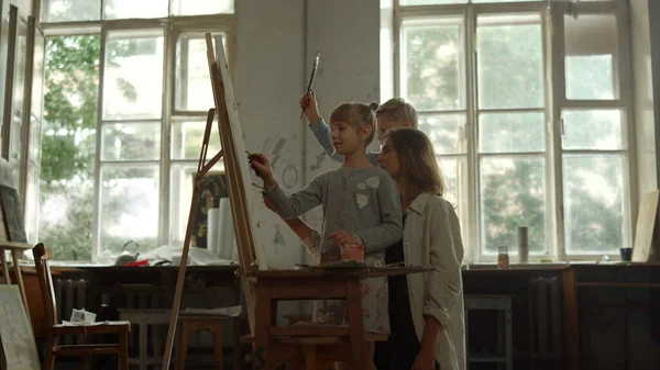 Talentueuse enseignante passe du temps avec un garçon et une fille à l'école d'art. — Photo