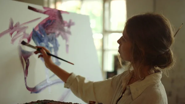 Stüdyoda çizim yapan genç bir kadın. Kapalı alanda palet kullanan yetenekli bir ressam.. — Stok fotoğraf