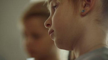 Odaklanmış kadın ressam vaktini yaratıcı okulda geçiriyor. Kız tuvale bakıyor.