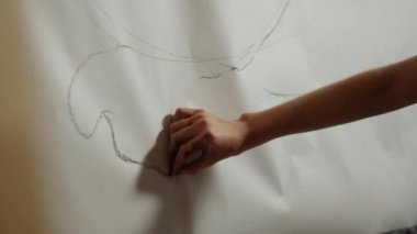 Bilinmeyen ressam beyaz arka plana resim çiziyor. Sanat stüdyosunda kuyruk oluşturan kadın.