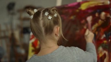Sanat atölyesinde küçük bir ressam. Sanat stüdyosunda kadın çocuk resimleri..