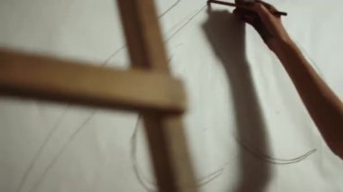 Bilinmeyen kadın ressam tuval üzerinde çizim yapıyor. İş yerinde kadın eli çizimi.