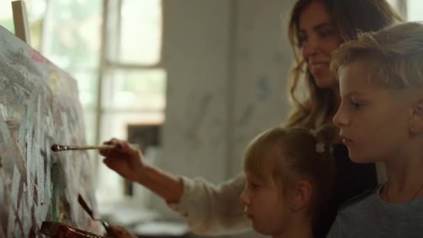 ครูหญิงและเด็ก ๆ วาดภาพในบ้าน ครอบครัวใช้เวลาในสตูดิโอศิลปะ . — วีดีโอสต็อก
