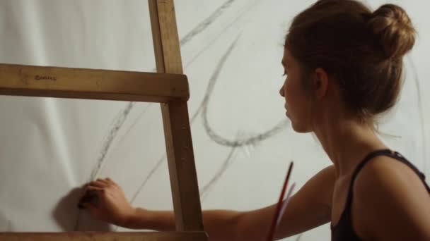 Γυναίκα καλλιτέχνης ζωγραφίζει σε λευκό φόντο. Δημιουργική γυναίκα που εργάζεται σε στούντιο τέχνης. — Αρχείο Βίντεο