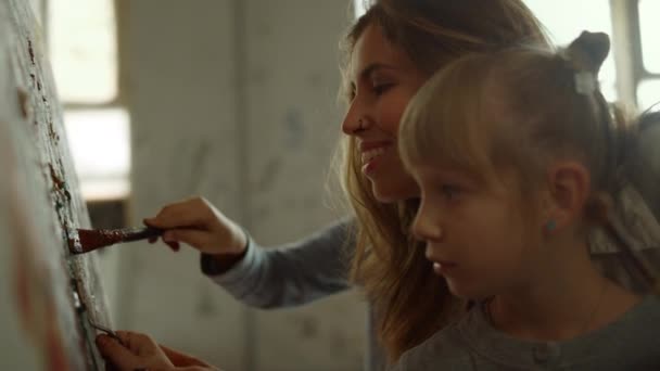 Vrouwelijke schilder geeft les aan kinderen in de studio. Jongen en meisje schilderen binnen. — Stockvideo