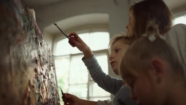 インスピレーションを受けた家族がスタジオで一緒に描く。筆を作る女教師. — ストック動画