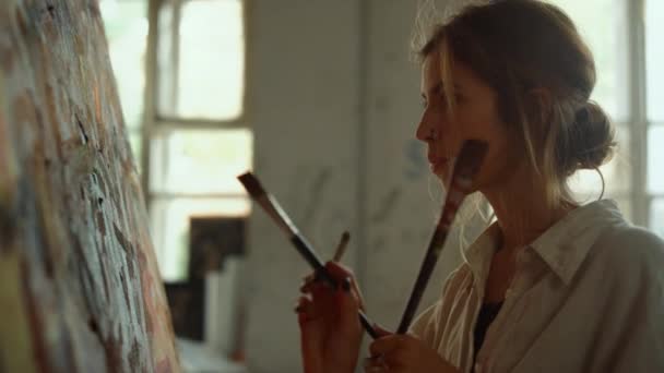 Талановита жінка тримає цигарку в приміщенні. Втомлений художник відпочиває в художній студії . — стокове відео