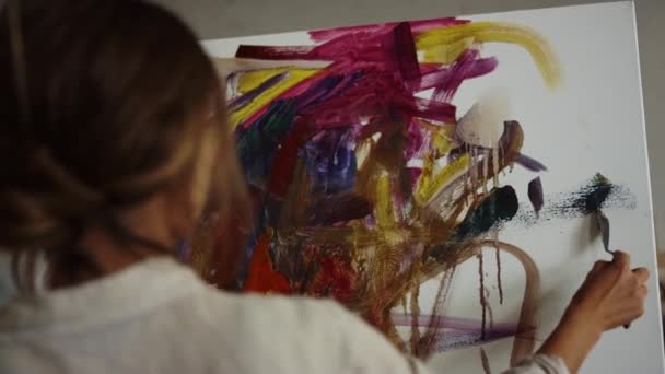 Femme créative dessiner à l'intérieur. Peintre talentueux utilisant un couteau de palette en studio. — Video