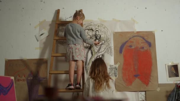 Madre e hija pasan tiempo en la escuela de arte. Chica talentosa pintura en interiores. — Vídeo de stock