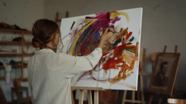 Εμπνευσμένη γυναίκα ζωγραφίζει στο στούντιο. Δημιουργικός ζωγράφος δημιουργεί έργα τέχνης εσωτερικού χώρου. — Αρχείο Βίντεο