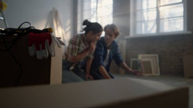 İnşaat geçmişinde oturan genç bir çift. Aile planlarını tartışıyor.