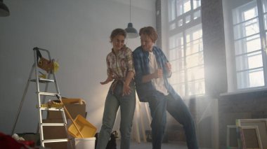 Neşeli çift arka arkaya eve yaslanıyor. Ev yenileme konsepti.