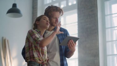 İçerideki tablete odaklanmış aile tasarımı. Yeni evde hesabı tutan adam.