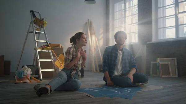 Family watching design project indoors. Couple discussing idea of home repair.