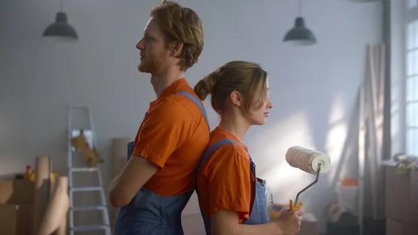 Casal feliz olhando para a câmera durante o reparo em casa. Conceito de renovação Diy. — Fotografia de Stock