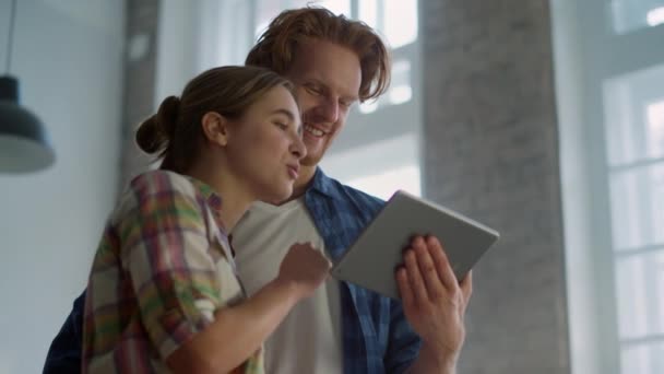 Χαρούμενο ζευγάρι που απολαμβάνει το σχεδιασμό ανακαίνισης σπιτιού με tablet σε εσωτερικούς χώρους. — Αρχείο Βίντεο
