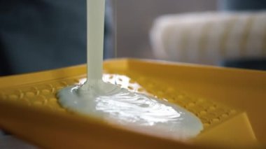 Bilinmeyen kişi yeni dairede sarı kabı beyaz boyayla dolduruyor..