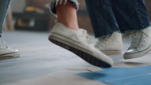 Paar benen maken stappen op de vloer. Man en vrouw voeten dansen tijdens reparatie. — Stockvideo