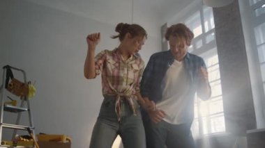 Neşeli bir aile apartman dairesini geliştiriyor. Mutlu çift içeride dans ediyor..
