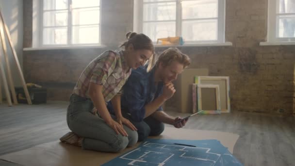 Junge Familie schafft Design-Projekt im Haus. Paar benutzt Tablet im Haus. — Stockvideo