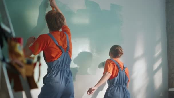 Vue arrière du mur de peinture de couple à l'intérieur. Famille faisant l'amélioration intérieure. — Video