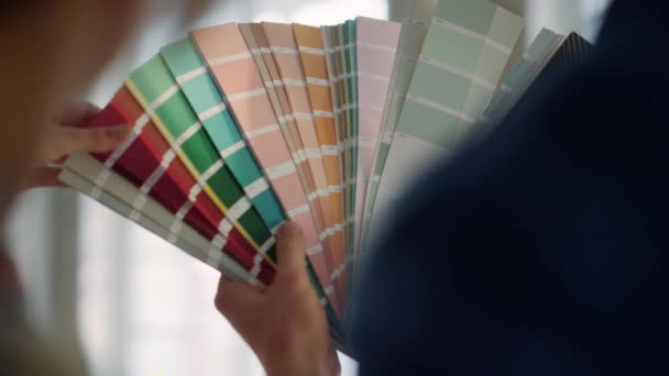 Les mains de femme touchant des échantillons réservent à l'intérieur. Couple inconnu utilisant la palette de couleurs. — Video