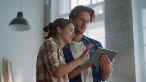 Happy couple using tablet for home repair. Family looking pictures online. — Stock Video