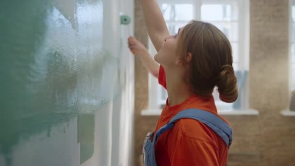 Gelukkige familie schilderen muur binnen. Paar plezier hebben terwijl je thuis repareert. — Stockvideo